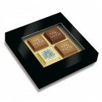 Silvester Pralinen mit Logo bedruckt direkt auf der Schokolade, verpackt zu 4 Stück in schwarzer Geschenkbox mit Sichtfenster.